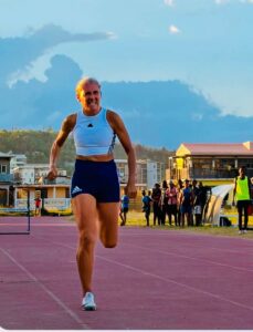 Accueil 23 Athlète vétérane courant une course de haies sur piste lors d’un championnat régional d’athlétisme à Mayotte dans un stade en plein air.
