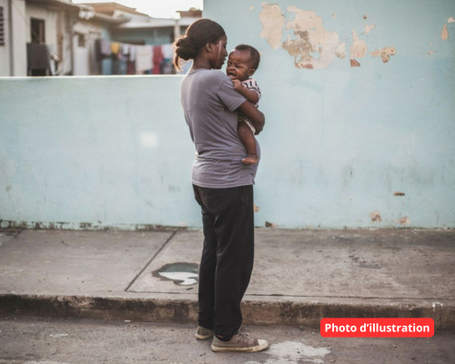 Des enfants plongés trop tôt dans des vies d’adulte et la violence 3 Jeune femme marchant avec un enfant dans les bras, illustrant les violences conjugales et la protection des victimes à Mayotte